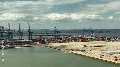 Aerial Gdańsk harbor and Stogi Beach, the container port with cranes and containers, as well as the sandy beach and waterfront. The scene combines industrial Baltic Hubu T3 new terminal DCT photo