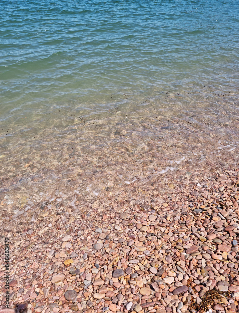 It is a beach with round pebbles.
It is a beach with round pebbles.