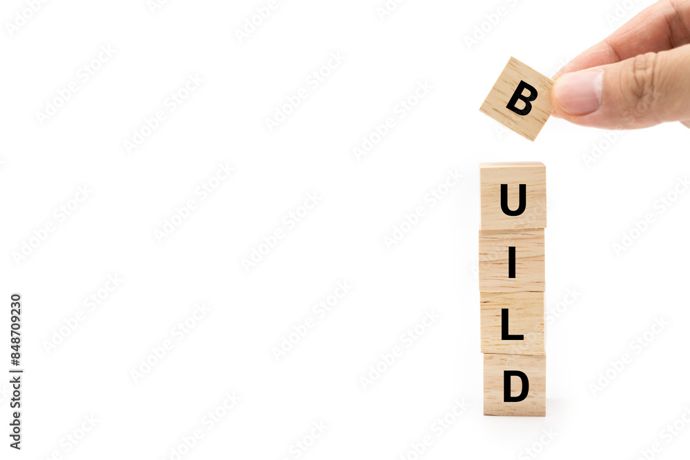 Hand putting wood cube block with BUILD text isolated on white background. Build your Brand. Brand building, success, business.