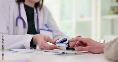 Female doctor places pulse oximeter on patient finger