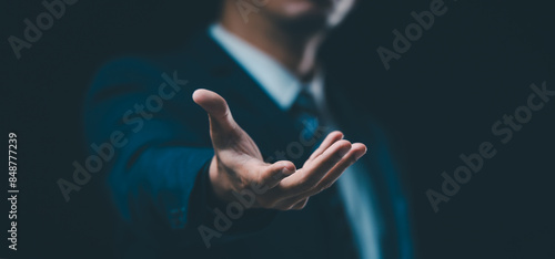 A male hand in a suit shows a palm-up gesture against a gray background, symbolizing concepts of request, bankruptcy, and close-up.