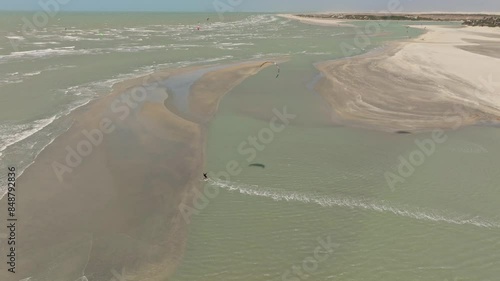 Kitesurfer cruising and jumping behind a sandbank near Guriu.