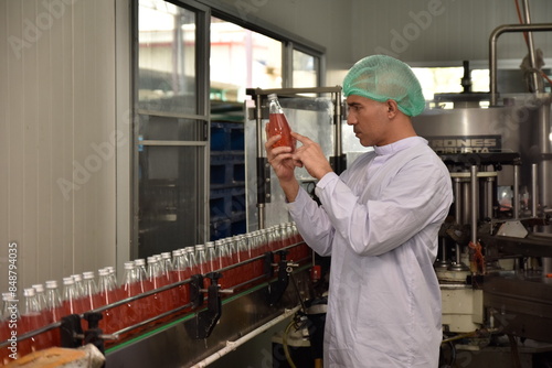 QC manager inspecting the quality of a beverage product in the production process photo