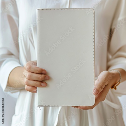 person holding blank notebook,Holding a flat, unstitched, unlogoed white leather notebook Job © Wong
