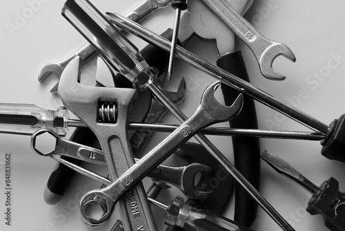 Variety scattered hand tools on a white shelf. Monochrome stock photo for repairing backgrounds photo