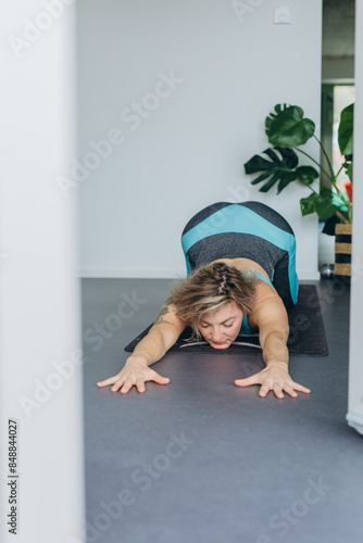 Attractive young woman practing yoga stretching yoga at home.  photo