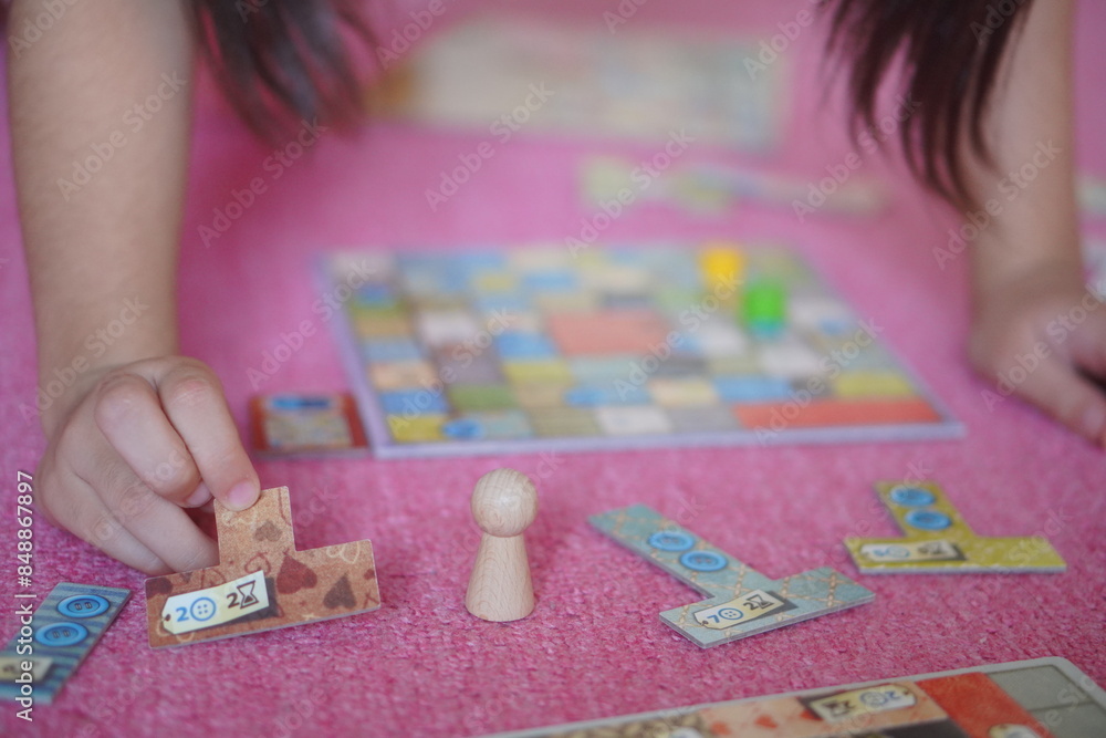 Fototapeta premium 小学生の子供がボードゲーム遊びを楽しんでいる様子。
