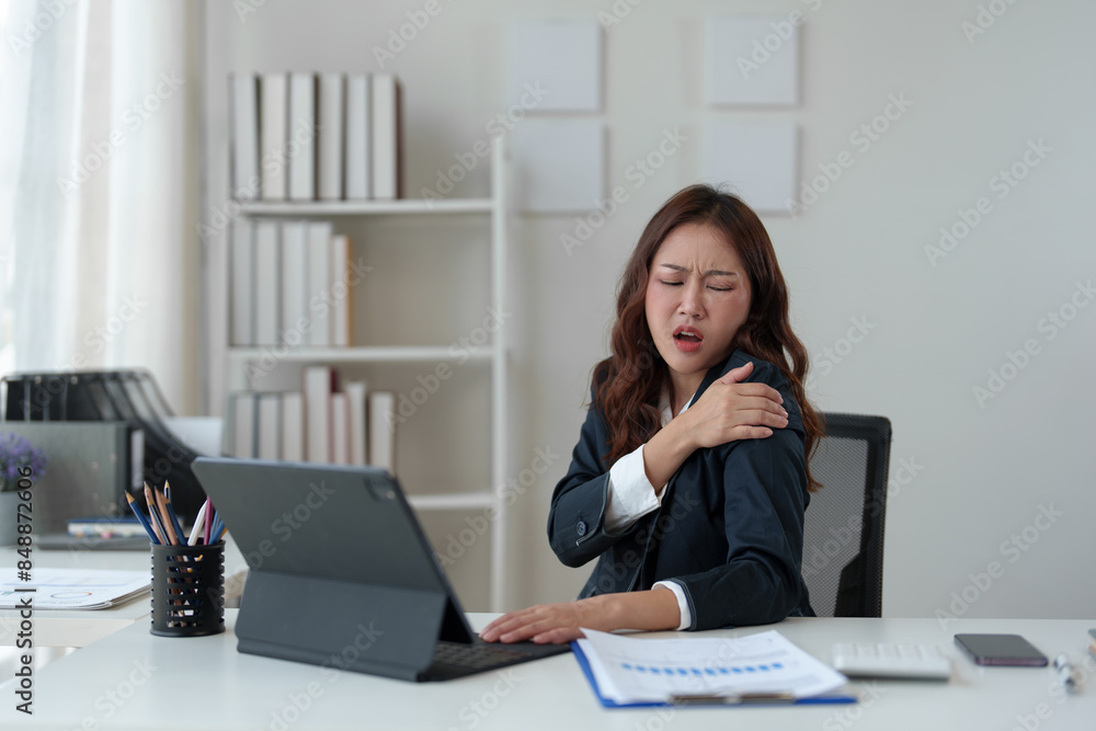 Tired businesswoman having a headache in modern office Creative woman working at a desk Ordinary female office worker Feel body aches while working hard on your laptop computer. Tired businesswoman having a headache in modern office Creative woman working at a desk Ordinary female office worker Feel body aches while working hard on your laptop computer.
