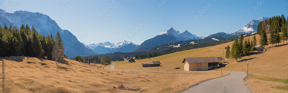 country road in idyllic landscape upper bavaria, with wooden huts, view to karwendel alps. Buckelwiesen. country road in idyllic landscape upper bavaria, with wooden huts, view to karwendel alps. Buckelwiesen.