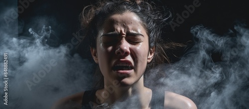 Closeup image of a furious young woman with steam coming from her ears on the verge of a nervous breakdown with a black background for copy space image