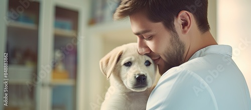 A lovely young woman is snuggling her stunning Labrador retriever puppy during a veterinary check up in a scene captured with copy space image photo