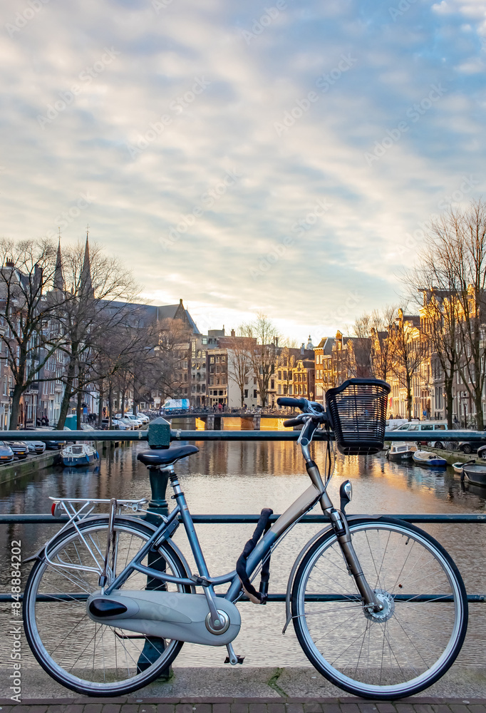 Bicycle and boats parked along the building lined canals in Amsterdam. Photo taken during the daytime in Amsterdam Holland Bicycle and boats parked along the building lined canals in Amsterdam. Photo taken during the daytime in Amsterdam Holland