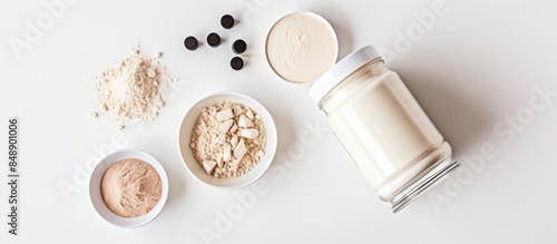 Sport nutrition displayed with whey protein a shaker and dumbbells on a white background in a top down flat lay with copy space image