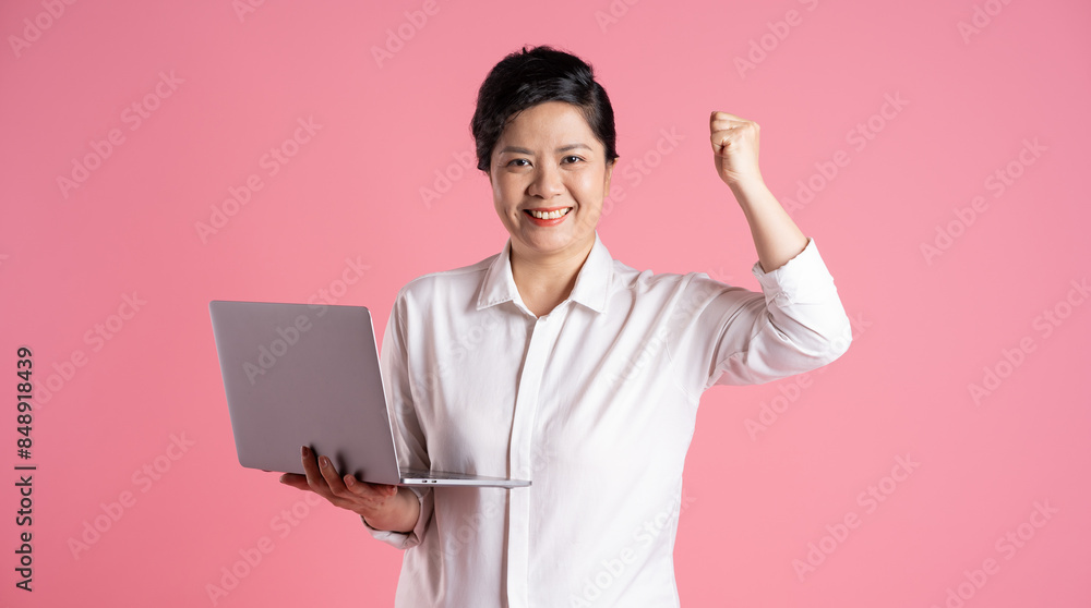 Image of older Asian businesswoman posing on pink background Image of older Asian businesswoman posing on pink background