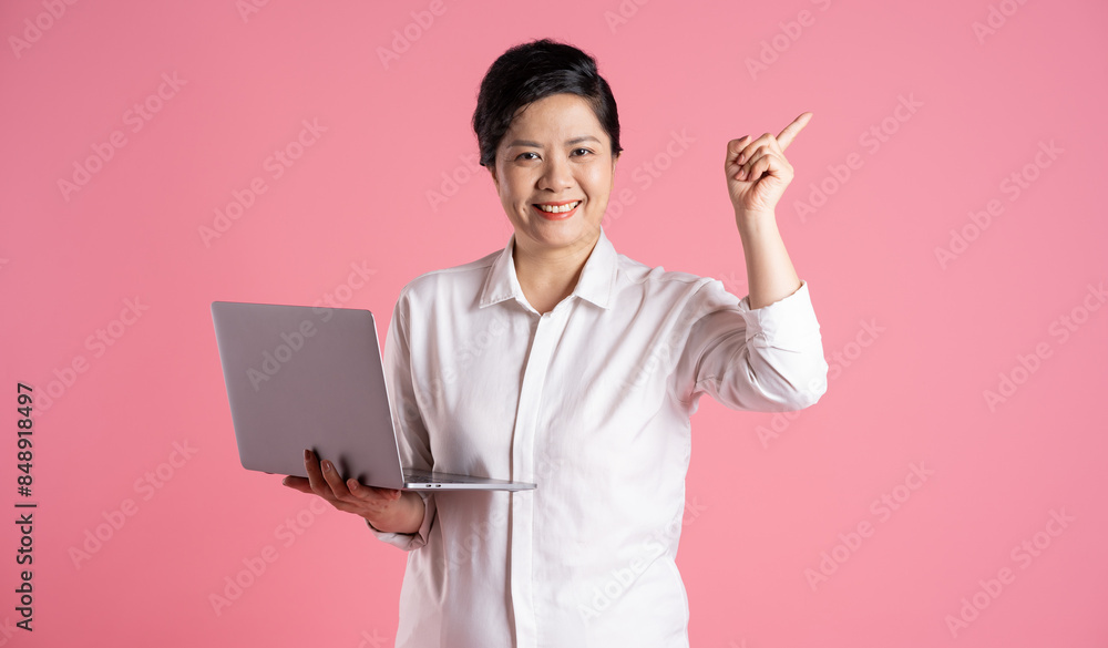 Image of older Asian businesswoman posing on pink background Image of older Asian businesswoman posing on pink background