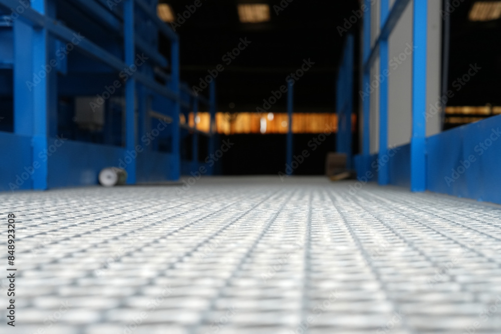 Obraz premium Metallboden einer Industrieanlage mit Licht im Hintergrund gerillter Boden