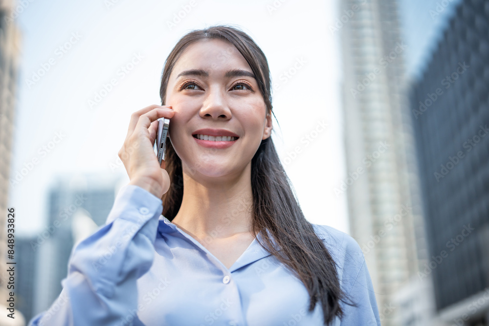Asian young businesswoman talking on smartphone while walk in the city. Asian young businesswoman talking on smartphone while walk in the city.