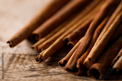 Cinnamon sticks dried tree bark spice on rustic wooden table background. Selective focus.