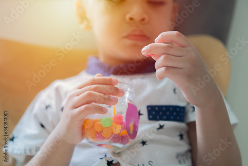 Gummy ball, kid has a good appetite, happy childhood, Close-up hands of child boy want to eat a sweet candy.