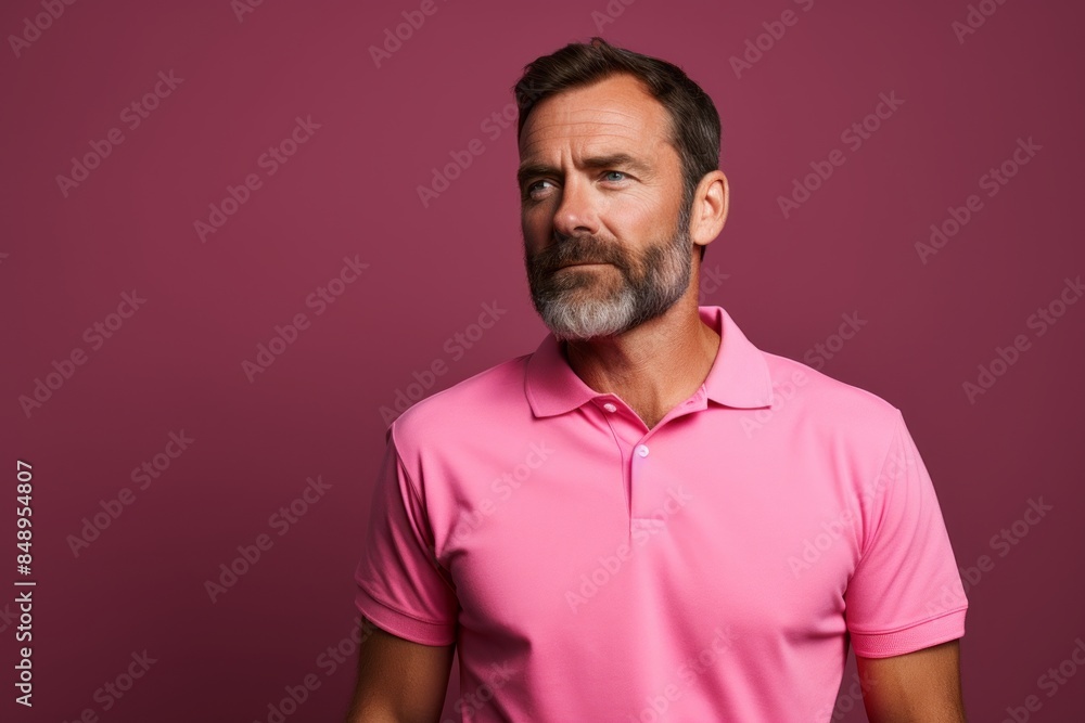 Obraz premium Portrait of a content man in his 40s wearing a breathable golf polo in solid color backdrop