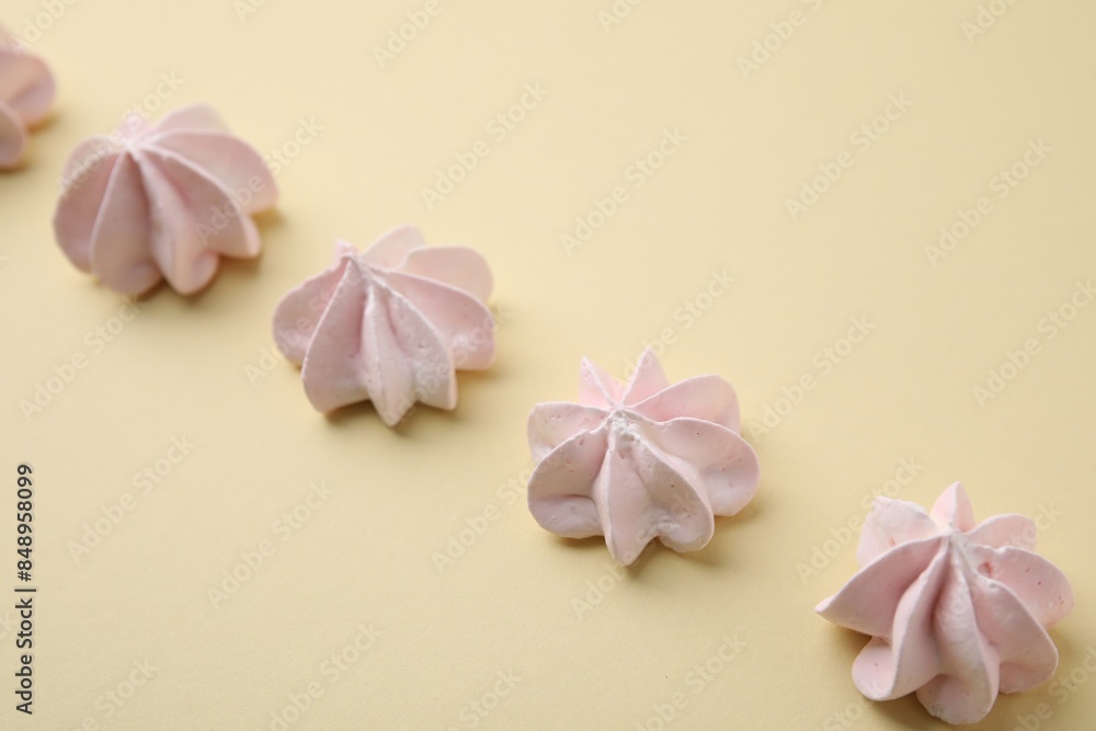 Delicious meringue cookies on beige background, closeup Delicious meringue cookies on beige background, closeup