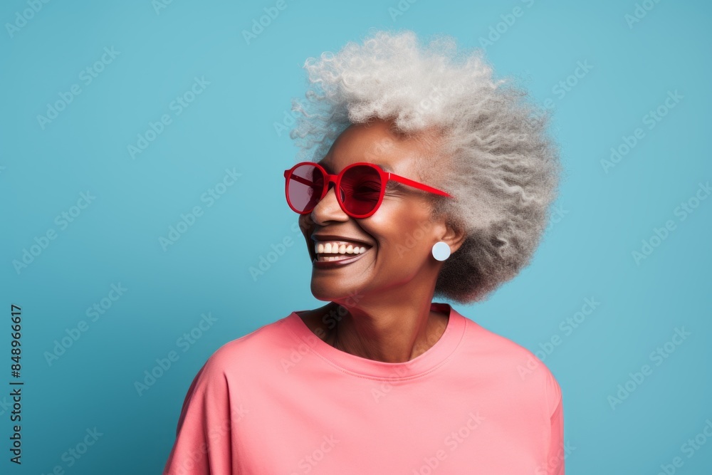 Portrait of a blissful afro-american elderly woman in her 90s wearing a sporty polo shirt in front of solid color backdrop Portrait of a blissful afro-american elderly woman in her 90s wearing a sporty polo shirt in front of solid color backdrop