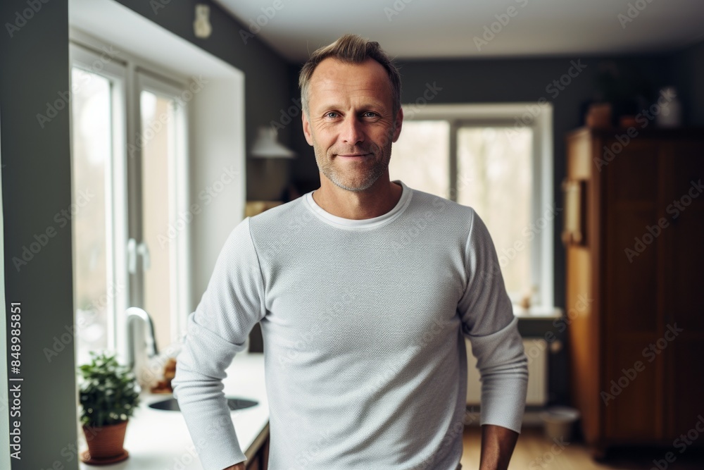 Portrait of a jovial man in his 40s sporting a long-sleeved thermal undershirt on scandinavian-style interior background Portrait of a jovial man in his 40s sporting a long-sleeved thermal undershirt on scandinavian-style interior background