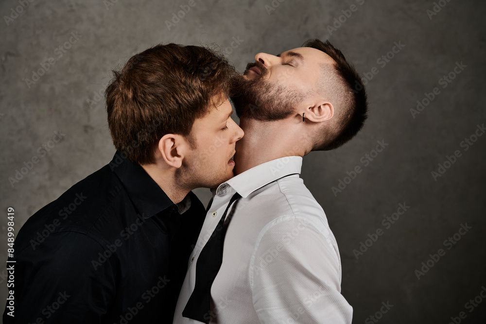 A loving gay couple in elegant suits share a tender moment. A loving gay couple in elegant suits share a tender moment.