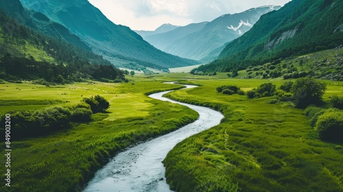 a winding river cutting through a verdant valley surrounded by mountains