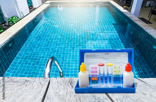 Swimming pool water tester test kit over on swimming pool edge, water quality check, pool maintenance calendar, water test kit, pool check list and report