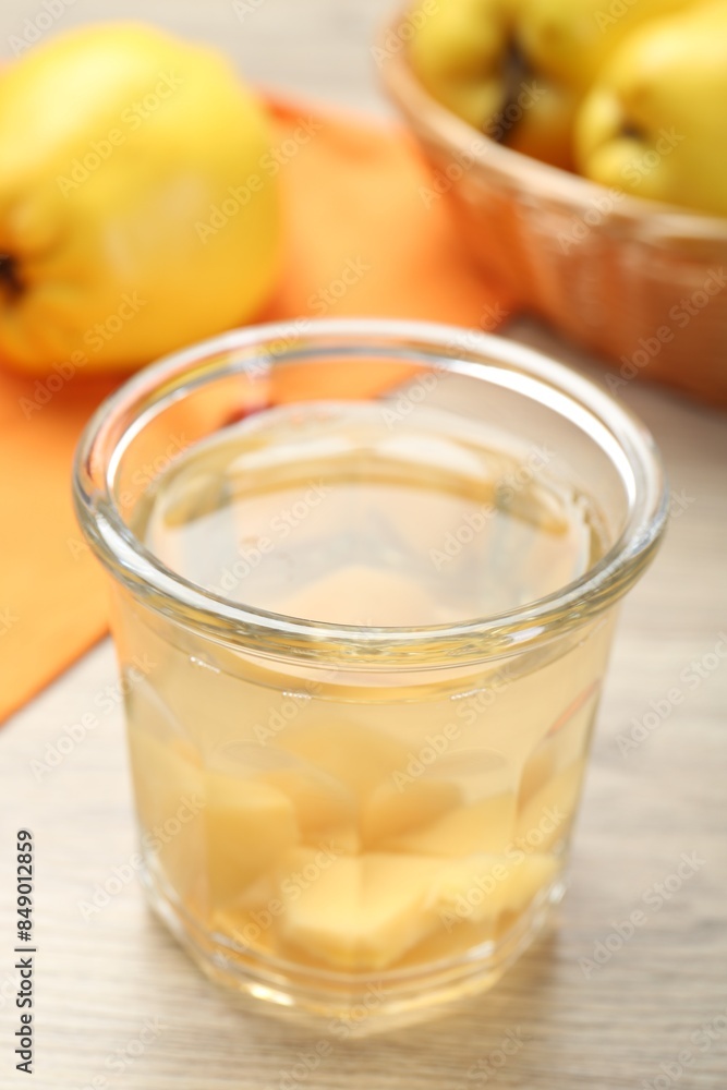Delicious quince drink in glass and fresh fruits on wooden table, closeup Delicious quince drink in glass and fresh fruits on wooden table, closeup