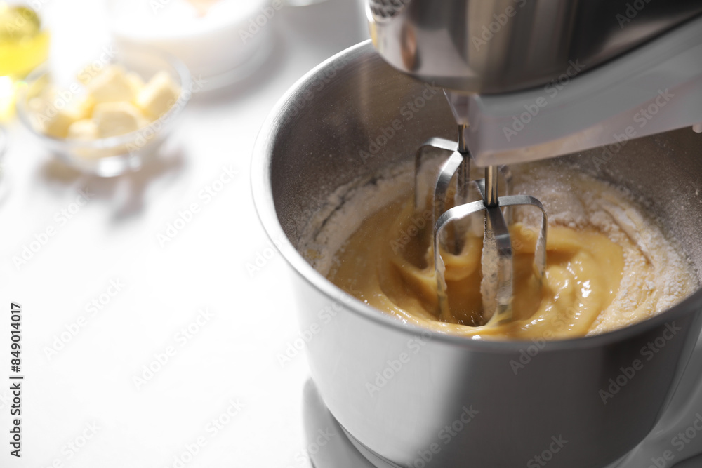 Making dough in bowl of stand mixer on white table, closeup. Space for text Making dough in bowl of stand mixer on white table, closeup. Space for text
