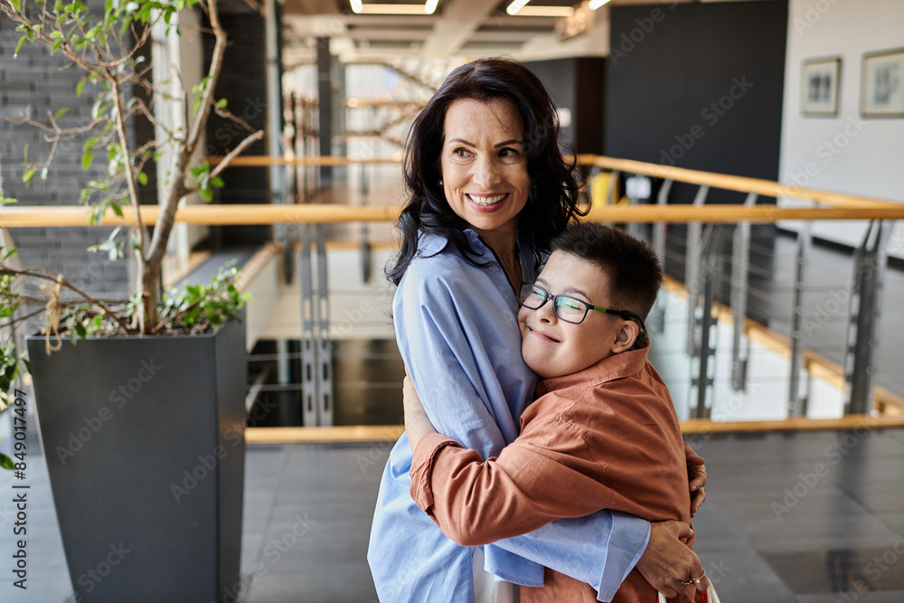Fototapeta premium A mother and son with Down syndrome share a loving embrace in a shopping mall.