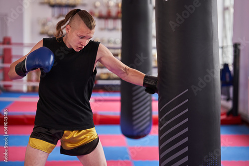 Kickboxer training on heavy bag in the gym © Xalanx