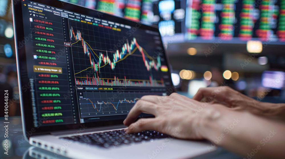Hands typing on a laptop with stock data Hands typing on a laptop with stock data
