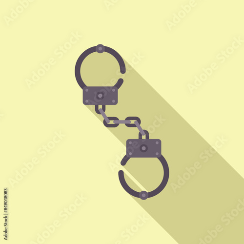 Pair of metal handcuffs with chain casting a long shadow are lying on yellow background
