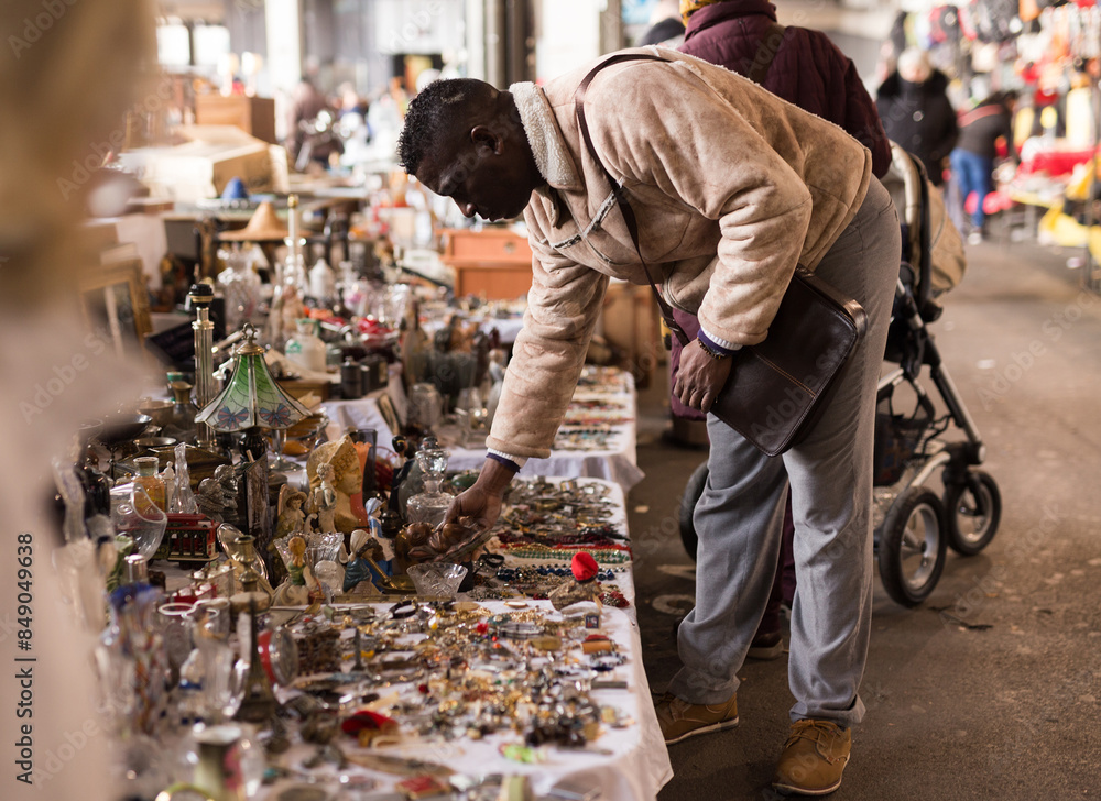 South African man selects antiques at a flea market South African man selects antiques at a flea market