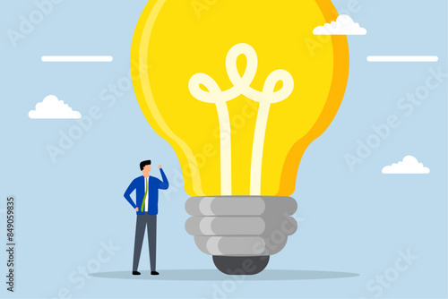 Think big, businessman entrepreneur who thinks with big oversized idea bulb.