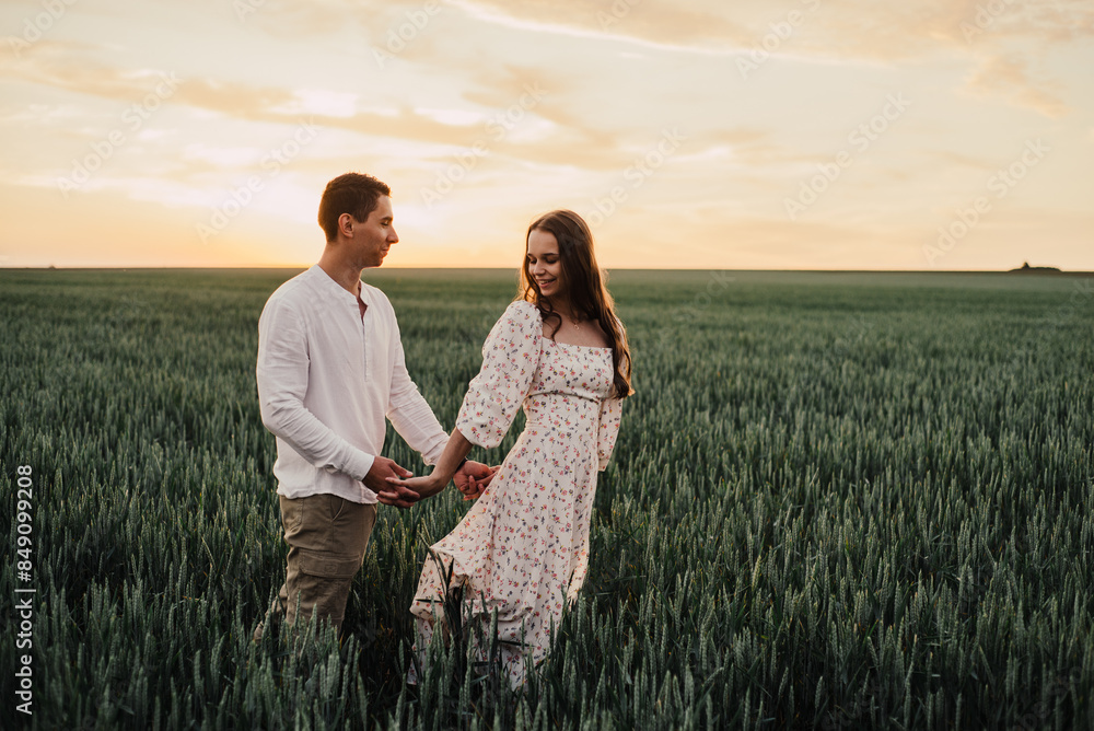 A married couple in a field of wheat at sunset in the afternoon. A married couple in a field of wheat at sunset in the afternoon.