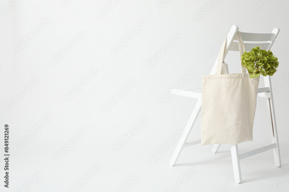 A white bag hangs on a white chair A white bag hangs on a white chair