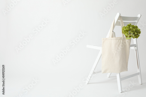 A white bag hangs on a white chair