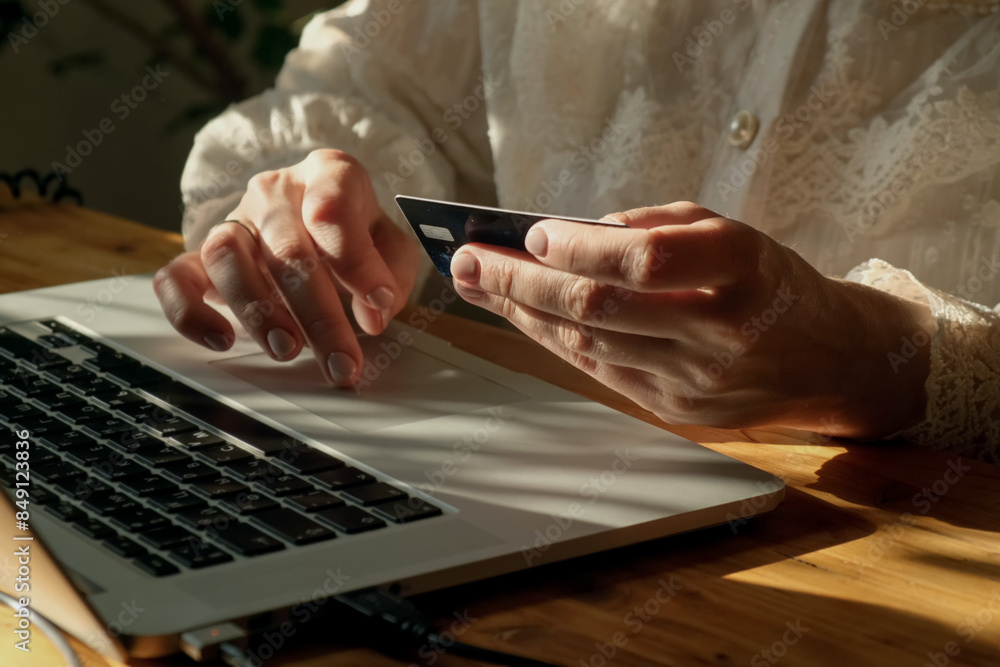 Woman making online payments using bank card sitting at desk. Woman making online payments using bank card sitting at desk.