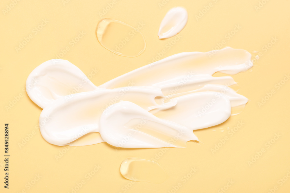 Samples of face cream on pale yellow background, top view Samples of face cream on pale yellow background, top view