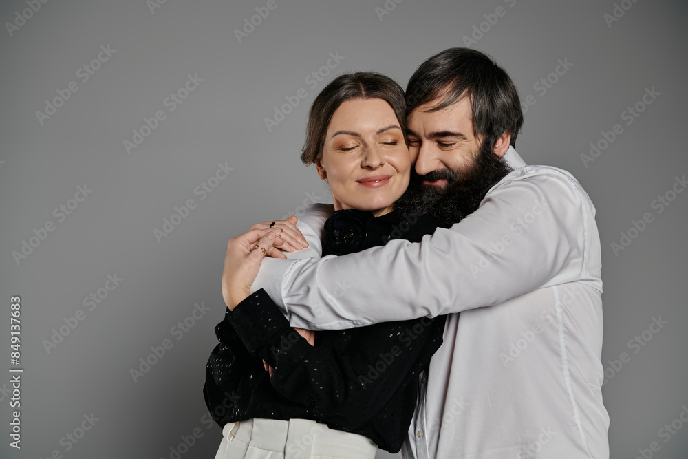 A loving couple in sophisticated attire poses for a portrait, embracing each other with tenderness. A loving couple in sophisticated attire poses for a portrait, embracing each other with tenderness.