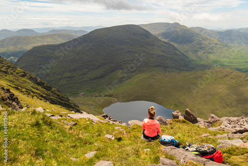 Hiker girl  on Devils Ladder, one of most difficult trails, that is leading to highest Irish mountain Carrauntoohill or Carrantuohill is the highest mountain in Ireland at 1038m photo