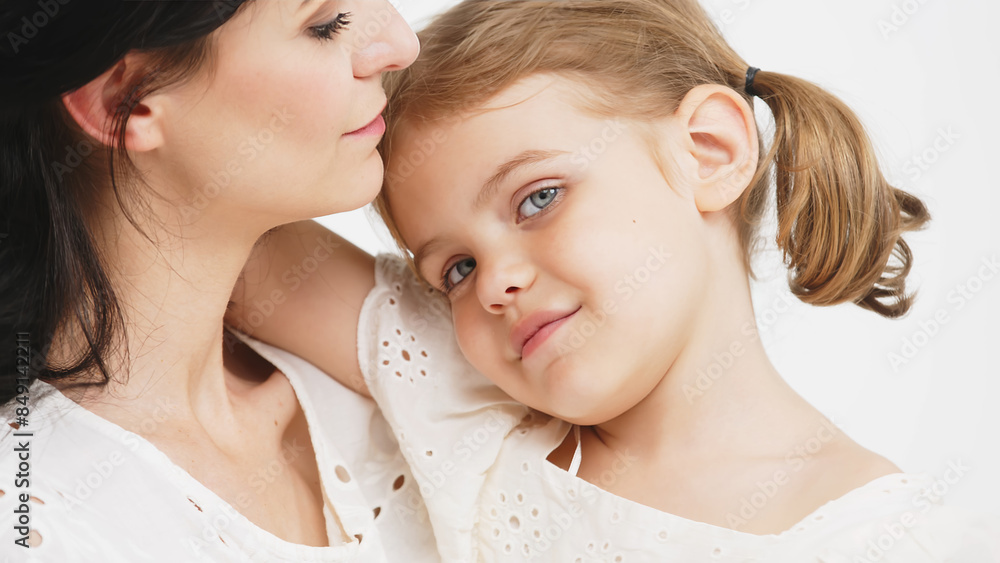 Mom's gentle touch. Close-up of a touching and tender mother and daughter on a light background. Family concept. Mom's gentle touch. Close-up of a touching and tender mother and daughter on a light background. Family concept.
