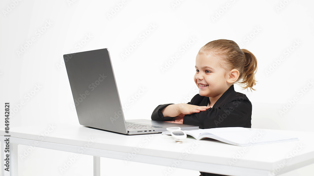 Stylish, business schoolgirl studying at a laptop on an isolated white background. Concept of modern technology, business and education. Stylish, business schoolgirl studying at a laptop on an isolated white background. Concept of modern technology, business and education.