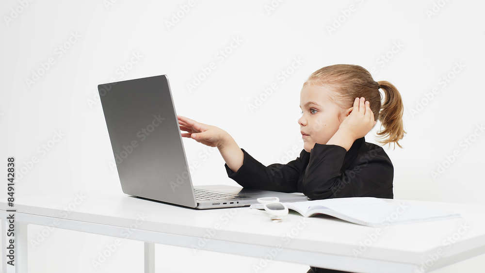 Stylish, business schoolgirl studying at a laptop on an isolated white background. Concept of modern technology, business and education. Stylish, business schoolgirl studying at a laptop on an isolated white background. Concept of modern technology, business and education.
