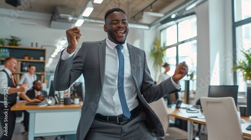 A man in a suit and tie dancing in an office