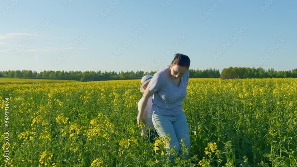 Mother And Son Playing In Field. Farmer And Little Boy Are Playing In Yellow Field Of Canola. Concept Of Organic Farming. Mother And Son Playing In Field. Farmer And Little Boy Are Playing In Yellow Field Of Canola. Concept Of Organic Farming.